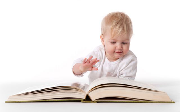 toddler reading a large book